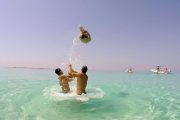 two guys and a girl having fun on a sandy lagoon in kornati