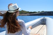 girl with hat and white shirt enjoying sun and speedboat ride