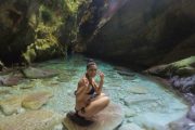 girl smiling and sitting at golubinka sea cave beach