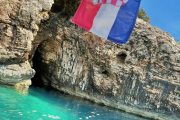 entrance to the golubinka sea cave, sea and croatian flag