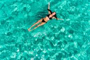 lady floating in pristine bay