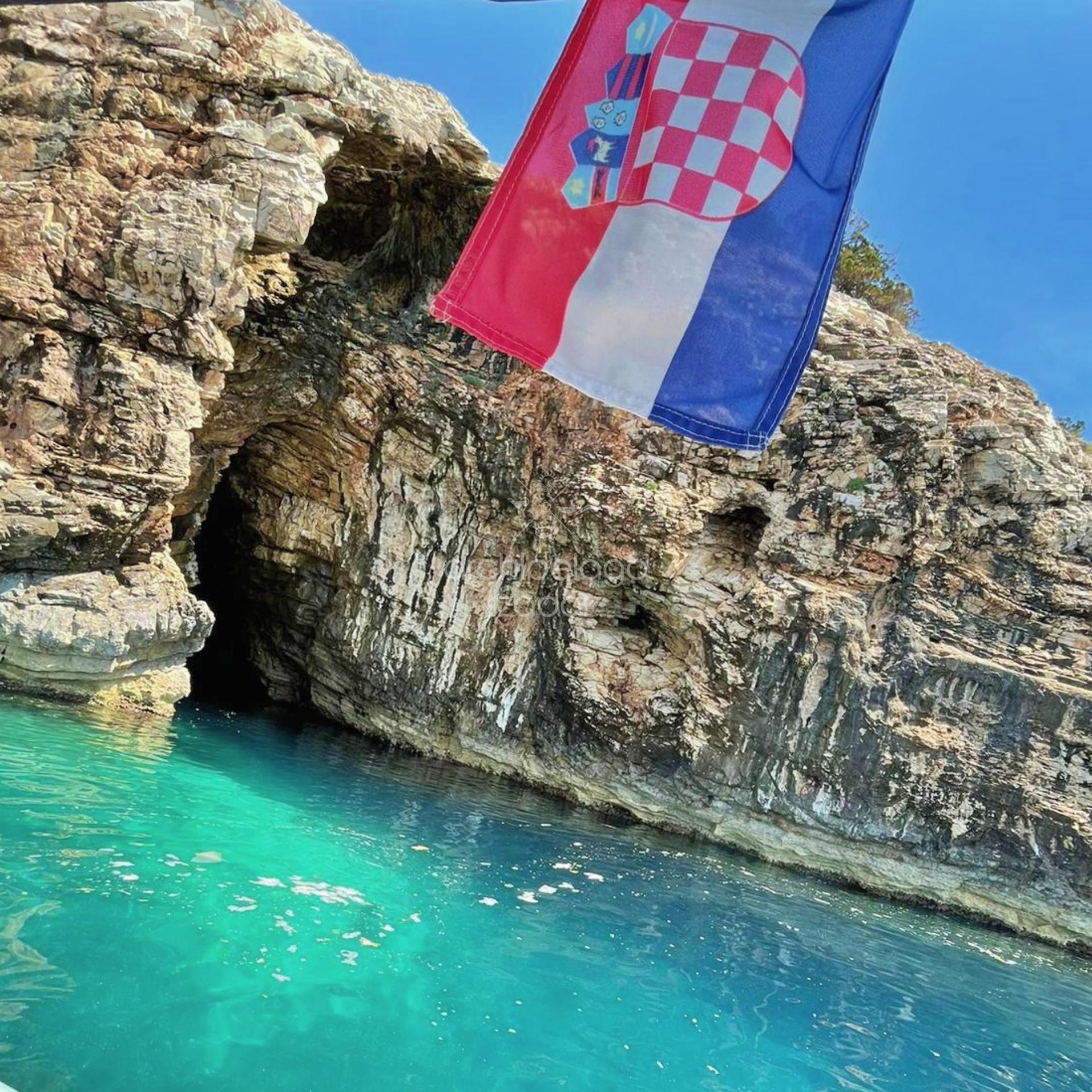 boat tour to golubinka sea cave entrance and croatian flag