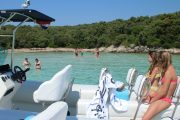 lolivul 9 boat rental people sitting on a boat & swimming near a beach