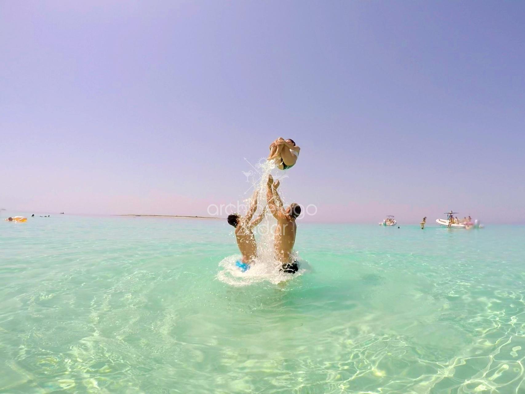 2 guys in the sea and girl doing summersault