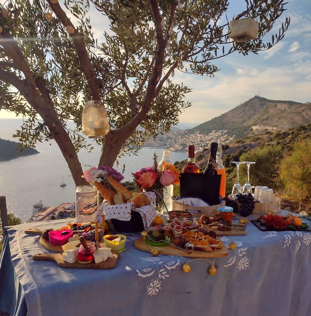 A picnic table set atop a hill, overlooking a town in the distance
